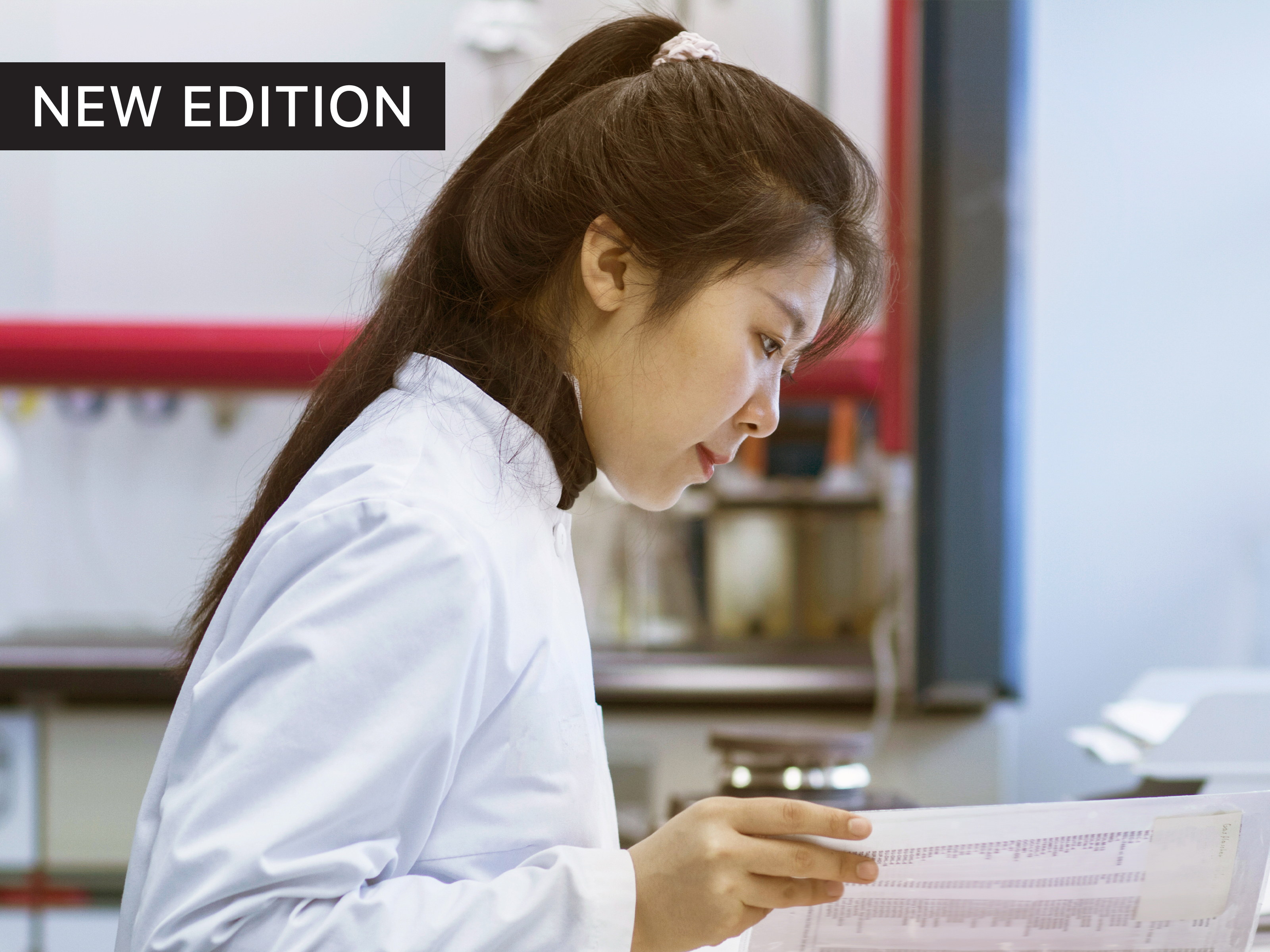 female researcher in a labcoat, at a desk looking concentrated, reviewing papers © Sigrid Gombert via Getty Images