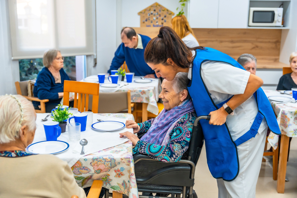 Pflegekraft unterhält sich mit Seniorin im Rollstuhl © unai / stock.adobe.com